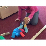 Die Kinder bauen für die Schulmaus einen Spielplatz aus Holzklötzen. 